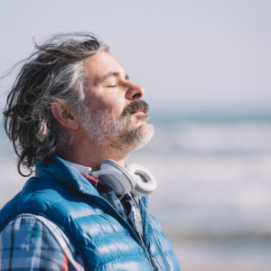 man with beard breathing by the ocean